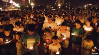 Residents gather as they attend a candlelight vigil for victims of a factory explosion, in Kunshan, Jiangsu province 2 August 2014