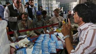 Afghan election commission workers sort ballot papers for an audit of the presidential run-off votes at an election commission office in Kabul, Afghanistan, Sunday, Aug. 3, 2014