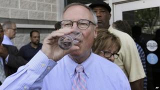 Toledo Mayor D Michael Collins drinks a glass of tap water after a news conference in Toledo, Ohio, 4 August 2014