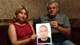 Seitumer Zinedinov and his wife Elvira hold a picture of their missing son Seiran
