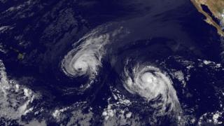 This image provided by NOAA shows Hurricane Iselle, center, and tropical storm Julio, right 6 August 2014