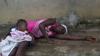 A Liberian woman weeps over the death of a relative from Ebola on the outskirts of Monrovia (6 August 2014)