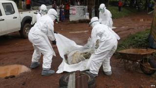Liberian nurses remove a victim of Ebola near Monrovia, Liberia, 8 August 2014