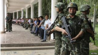 Paramilitary policemen stand guard during a ceremony to award those who the authorities say participated in "the crackdown of violence and terrorists activities" in Hotan, Xinjiang 3 August 2014