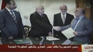 Iraqi President Fuad Masum (2nd L) shakes hands with deputy parliamentary speaker Haidar al-Abadi who has been tasked with forming a government ( image from Iraqi state TV)