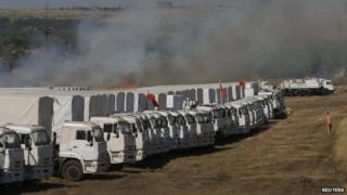 Smoke from a burning grass rises over the Russian convoy