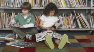 Two children sit and read