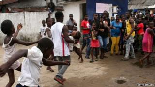 A man carries out a girl from an Ebola isolation centre as a mob overruns the facility in the West Point slum on August 16, 2014 in Monrovia, Liberia.