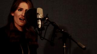 Ilse singing into a microphone in the studio