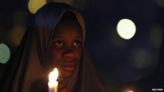 A campaigner of "#Bring Back Our Girls" holds candles during a candlelight vigil for Ameyo Stella Adadevoh and other Ebola victims in Abuja August 26, 2014. Adadevoh, a consultant physician and endocrinologist, died after contracting the deadly Ebola virus while treating a Liberian-American, Patrick Sawyer, and other victims of the disease in Nigeria.