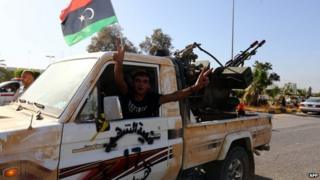 An Islamist fighter from the Fajr Libya (Libyan Dawn) coalition flashes the V sign for victory at the entrance of Tripoli international airport on 24 August 2014