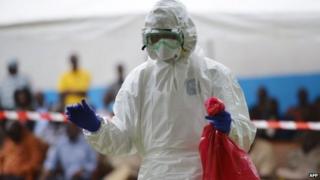 A man prepares to take off his protective suit at Biankouma's hospital during a simulation, on August 14, 2014.