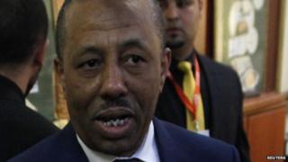 Libya's Prime Minister Abdullah al-Thinni (C) talks with media while visiting a polling station inside a school in Tripoli, June 25, 2014.