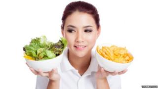 Woman choosing between salad or chips