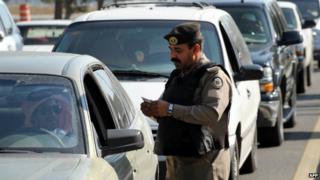 A Saudi policeman checks the ID card of a driver at a checkpoint in the east of the country - 25 November 2011