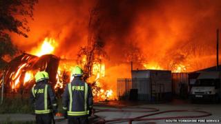 Two firefighters in front of a fire