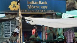 In this photograph taken on August 22, 2014, Indian customers eat at a roadside restaurant outside a bank in Calcutta