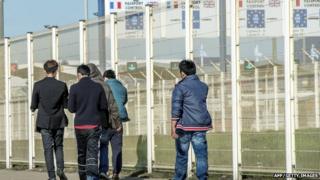 Migrants walk past the ferry terminal in Calais