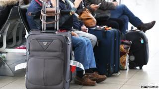 Passengers sit with their luggage while waiting to board a flight in the domestic terminal at Sydney Airport on Wednesday, 27 August, 2014