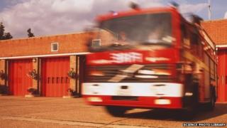 A fire engine leaves a fire station