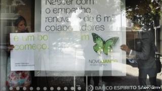 Staff changing the advertising sign to Nova Banco