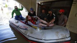 A rescue team of Kashmiri volunteers evacuate an elderly flood victim from her inundated house in Srinagar, on Sunday, Sept 14, 2014