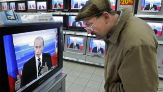 Russian TV viewer/President Putin on news - file pic