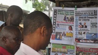 People read newspaper front pages in Monrovia