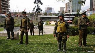 Police officers stand guard in an area where a bomb exploded in Santiago - 8 September 2014