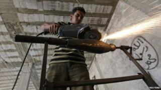 A rebel fighter makes improvised mortar shells inside a weapons factory in the southern countryside of Idlib 9 September 2014