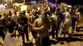 Ferguson protestors march through the streets at night