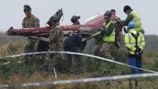 Crew carrying helicopter wreckage