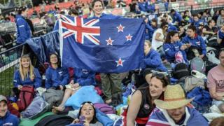 A woman holds the New Zealand flag during the ceremony celebrating the 99th anniversary of the Anzac Day in Canakkale on April 24, 2014