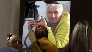 People sign a condolence book for French mountain guide Herve Gourdel in Nice