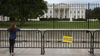 A young girl stands at a added security fence outside of the White House on 25 September 2014