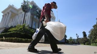 A man is seen carrying plastic bags in Sacramento, California, on 12 August 2014