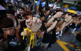 Protesters hold their hands as they gather around the Golden Bauhinia Square during an official flag raising ceremony to commemorate the Chinese National Day in Hong Kong, October 1, 2014.