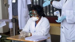 Health agents checking passengers leaving Liberia at the Roberts International Airport near Monrovia in August