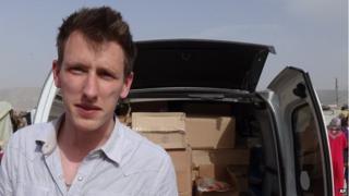An undated photo provided by Kassig family shows Abdul-Rahman Kassig standing in front of a truck filled with supplies for Syrian refugees.