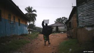 A resident in New Kru Town, Liberia, walks through the deserted streets - October 4, 2014