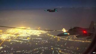 A handout photo taken 5 October 2014 and obtained on 9 October shows two Royal Australian Air Force (RAAF) F/A-18F Super Hornet aircraft refuelling from a RAAF KC-30A Multi Role Tanker Transport aircraft above a city in Iraq.