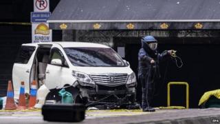 A member of a Malaysian bomb squad unit investigates the scene where a grenade exploded in Kuala Lumpur, Malaysia, on 9 October 2014