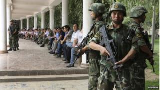 Paramilitary policemen stand guard during a ceremony to award those who the authorities say participated in "the crackdown of violence and terrorists activities" in Hotan, Xinjiang Uighur Autonomous Region 3 August 2014