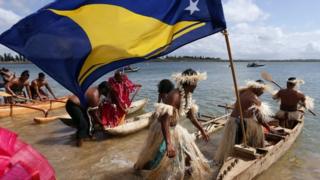 Traditionally dressed representatives from South Pacific nations push their canoes into the water as they prepare to participate in a protest aimed at ships leaving the Newcastle coal port, located north of Sydney October 17, 2014.