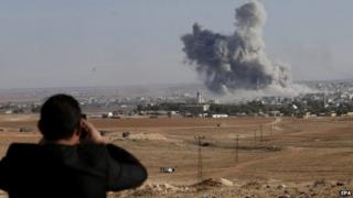 A man watches from a hill as smoke rises after an US-led coalition airstrike on Kobane, Syria, on the Turkish side of the border, near Suruc district, Sanliurfa, Turkey, 18 October 2014