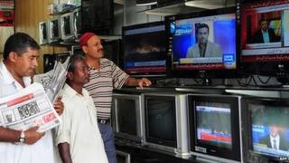 Pakistani viewers watch television news broadcasts at an electrical store in Karachi, Pakistan on 2 May 2011