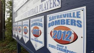 Championship banners for the town high school American football team hang from a wall in Sayreville, NJ