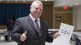 Toronto Mayoral Candidate Doug Ford gives a thumbs up to reporters after casting his ballot in advance voting for the Toronto Municipal Election at an Etobicoke polling station on 15 October 2014