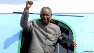 Michael Sata gestures upon arrival at Solwezi airport before addressing supporters at an election campaign meeting in September