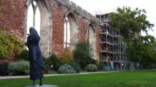Scaffolding around the stone arch window being repaired